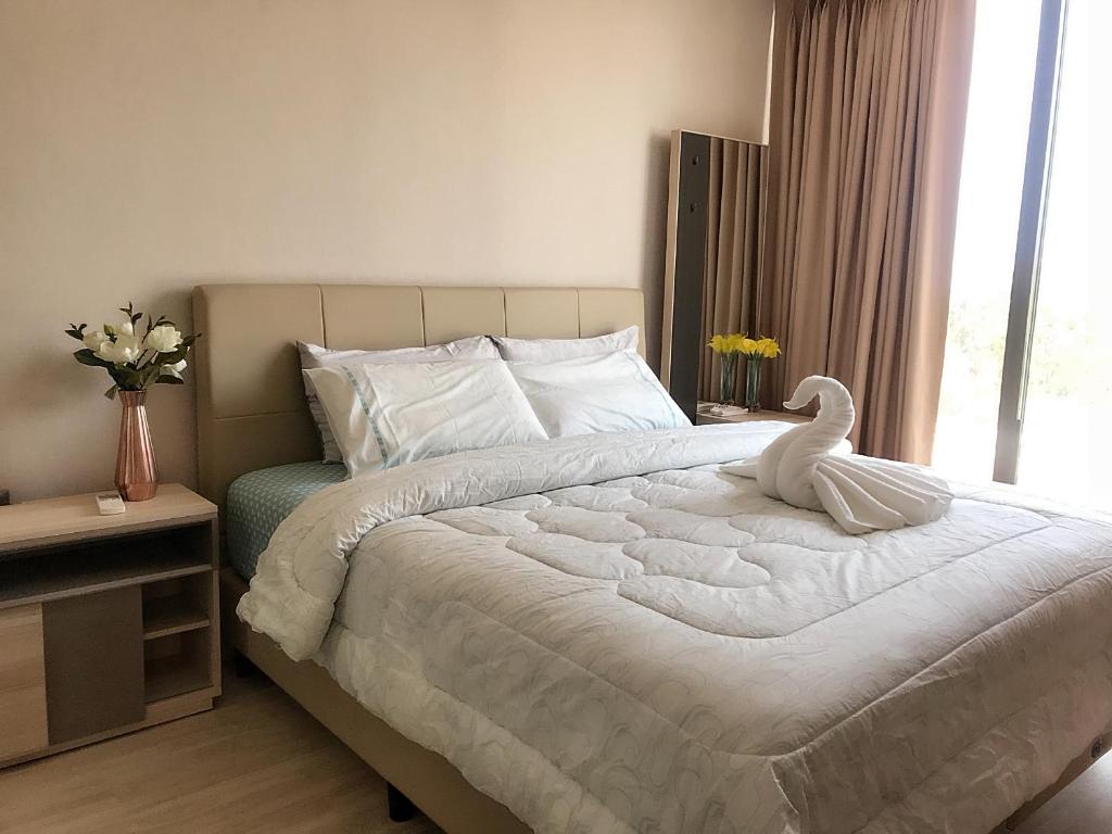 华欣The Pine Hua Hin的卧室配有白色的床和天鹅
