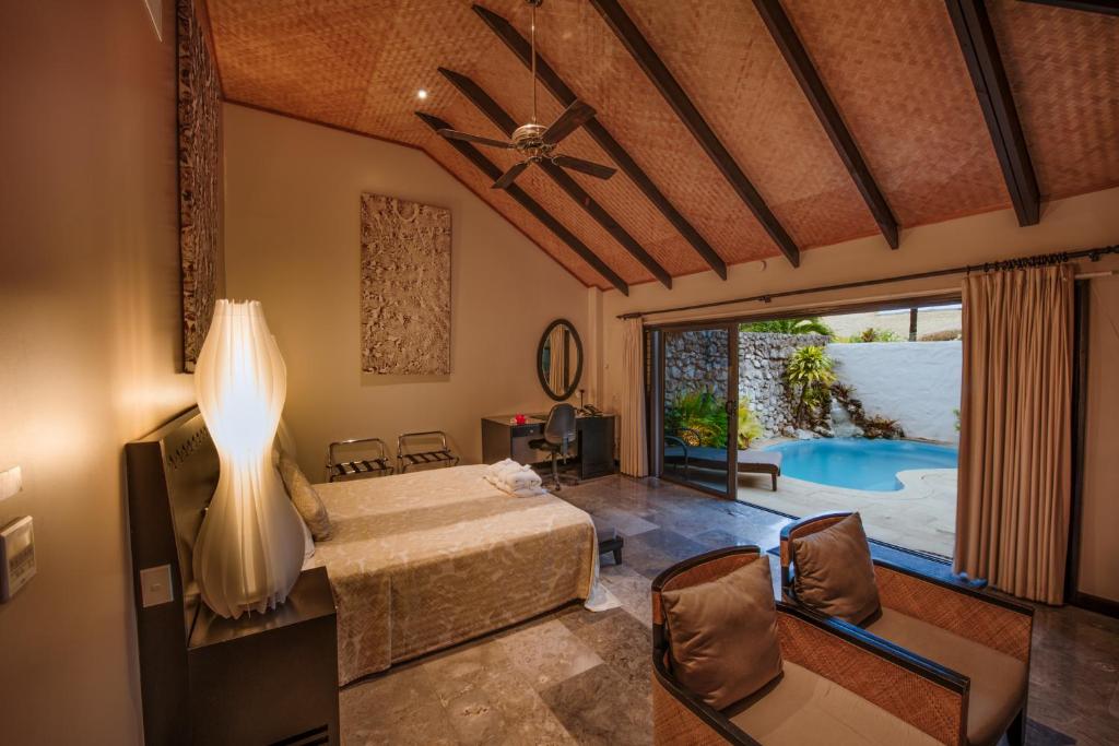 拉罗汤加皇冠海滩度假村和温泉中心的一间卧室设有一张床和一个游泳池