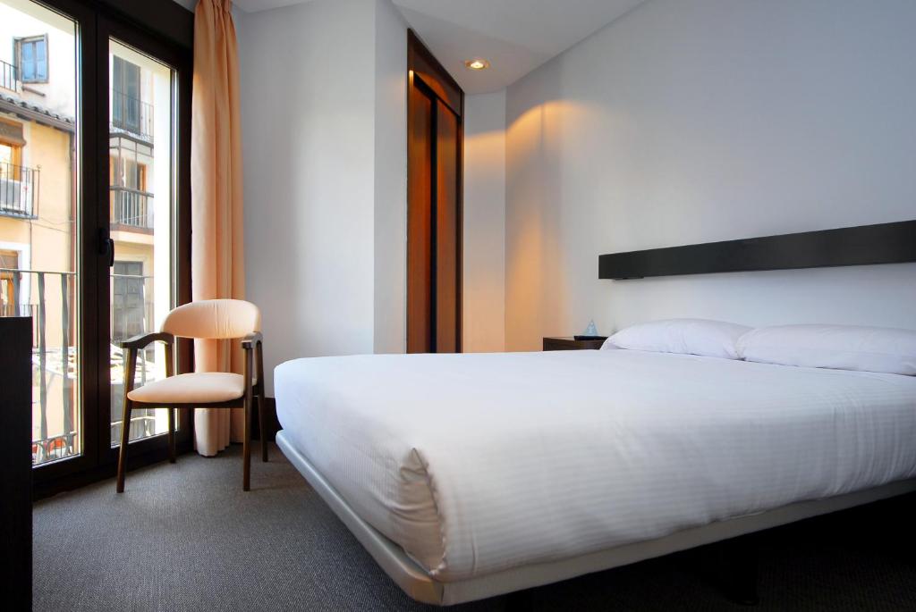 托莱多则卡多瓦广场多莫斯酒店的卧室设有一张白色大床和一扇窗户。
