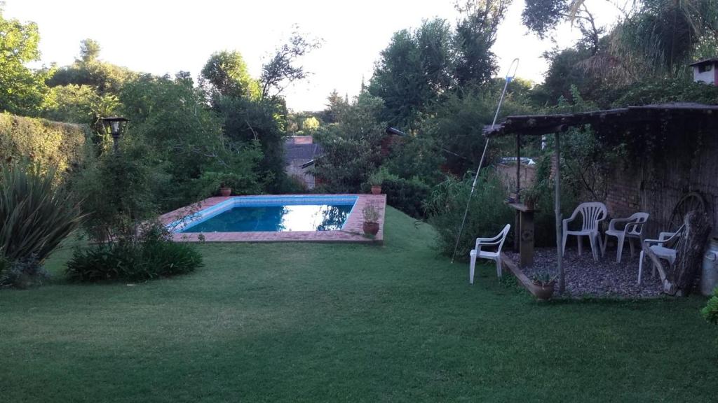 拉库布蕾Cabaña El Cristo的后院设有游泳池和草地上的椅子