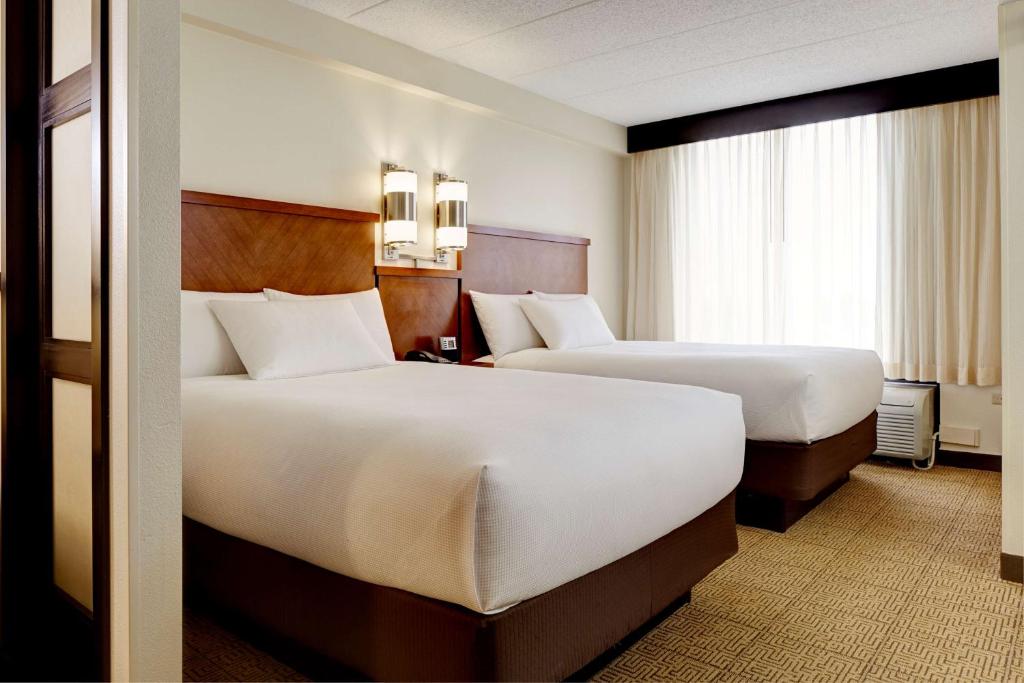 亚特兰大亚特兰大巴克海特凯悦酒店的酒店客房设有两张床和窗户。