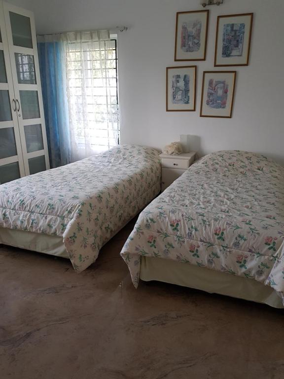 钦奈Elysium Kovalam的一间卧室设有两张床和窗户。