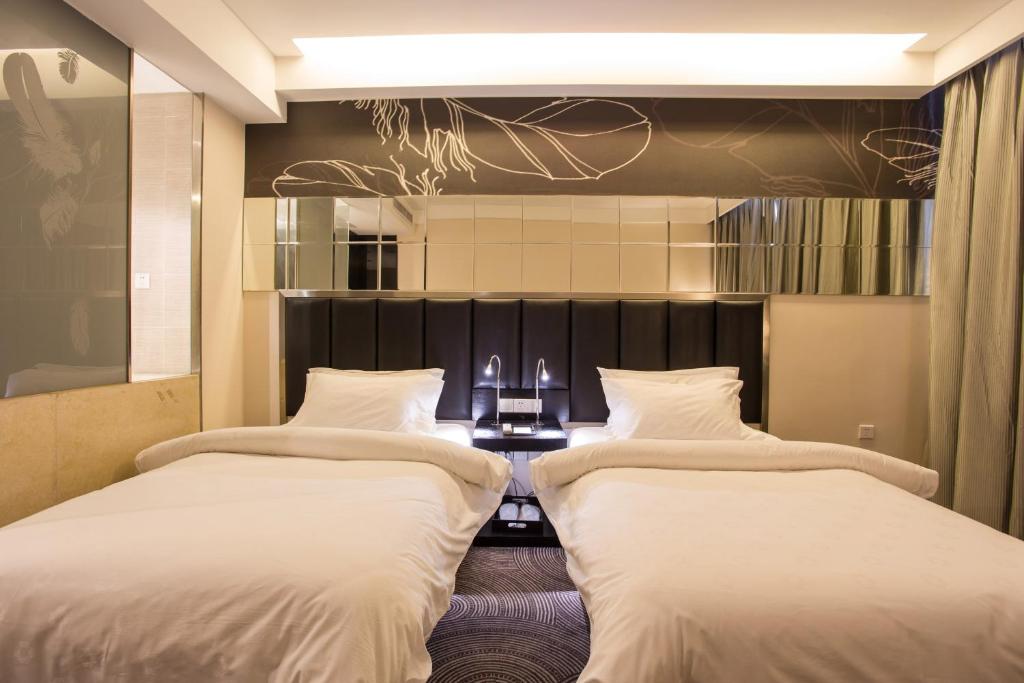 合肥锦江都城合肥天鹅湖酒店的配有桌子的酒店客房内的两张床