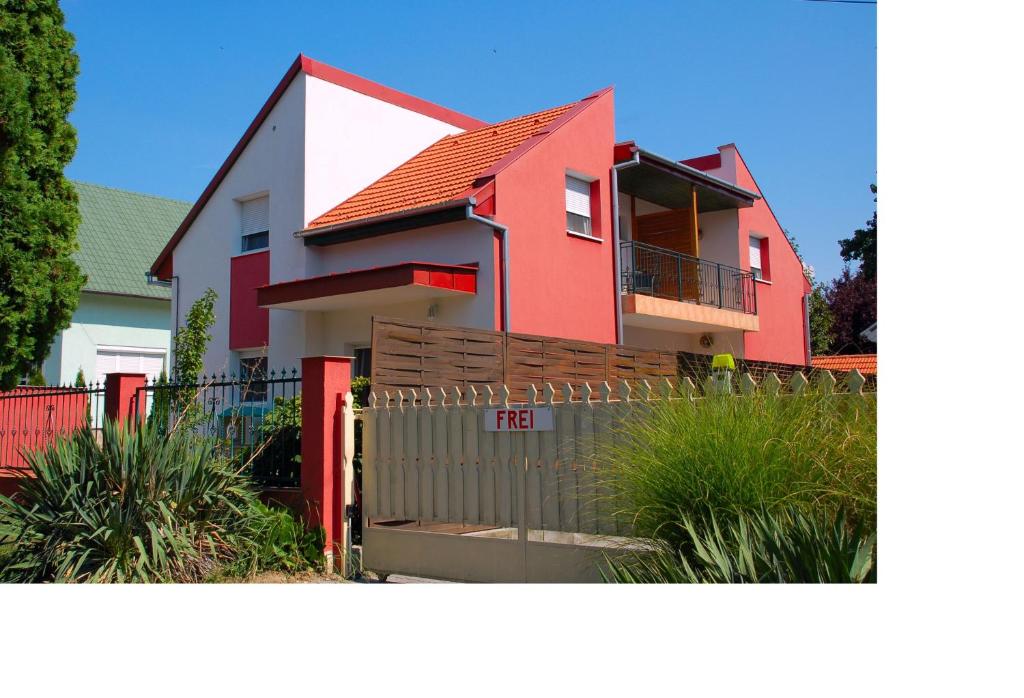 佐洛卡罗斯Laci Apartman的一座红色和白色的房子,设有围栏