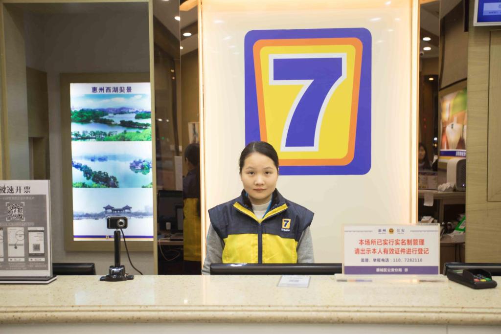 惠州7天连锁酒店惠州西湖店的站在商店柜台后面的女人