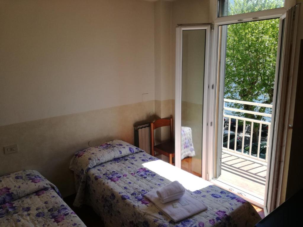 洛韦雷贝维德雷酒店的一间卧室设有两张床,窗户设有阳台