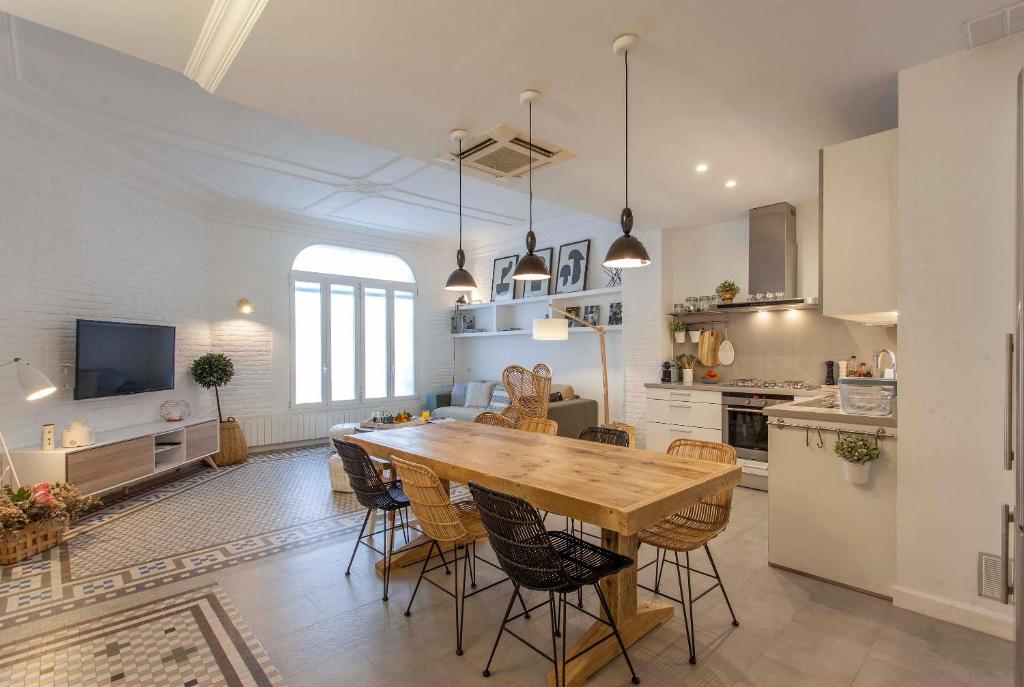 瓦伦西亚Valencia Flat Rental Ensanche 1的厨房以及带木桌和椅子的用餐室。