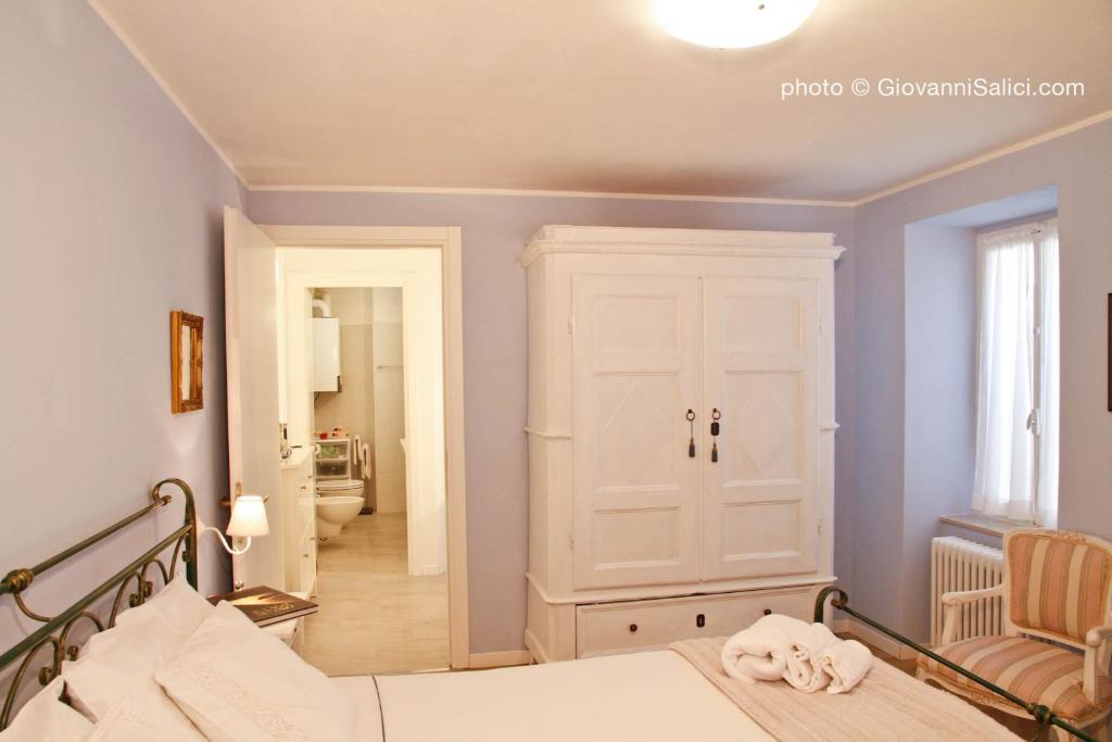 梅纳焦Casa Azzurra的一间卧室配有一张床,走廊配有镜子