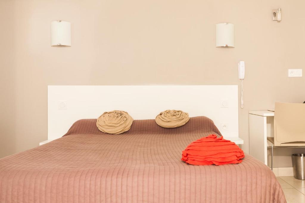 AlbaronLogis Hotel Restaurant Le Flamant Rose camargue的一间卧室配有一张带两个枕头的床