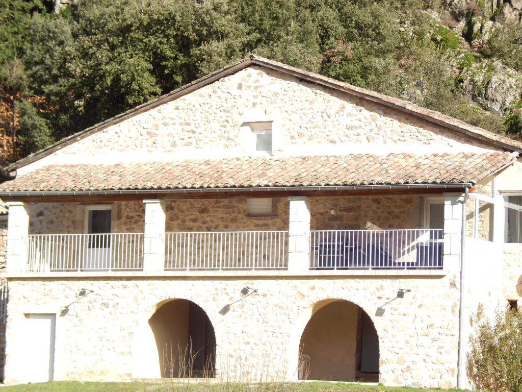 Jaujacla maison de bonneval的石头房子的顶部设有阳台