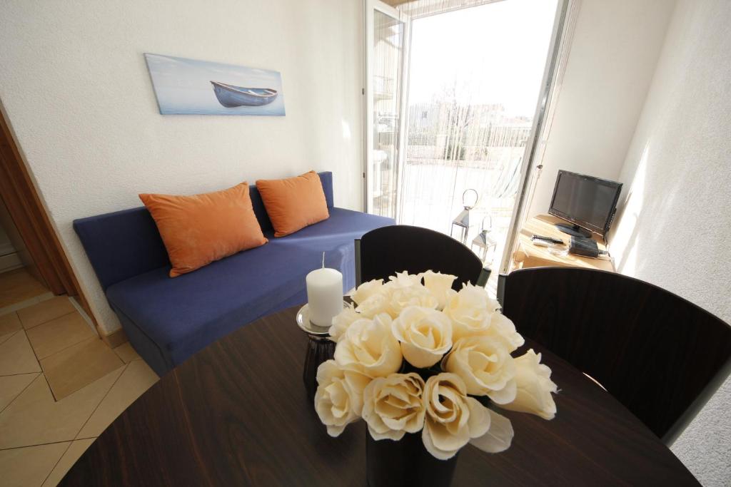 巴什卡沃达Apartmani Znaor的客厅配有沙发和鲜花桌