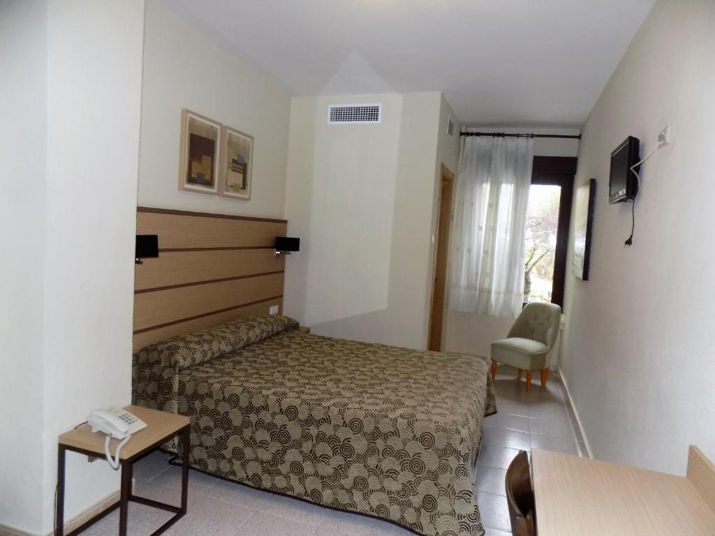 隆达皇家酒店的酒店客房配有一张床铺和一张桌子。