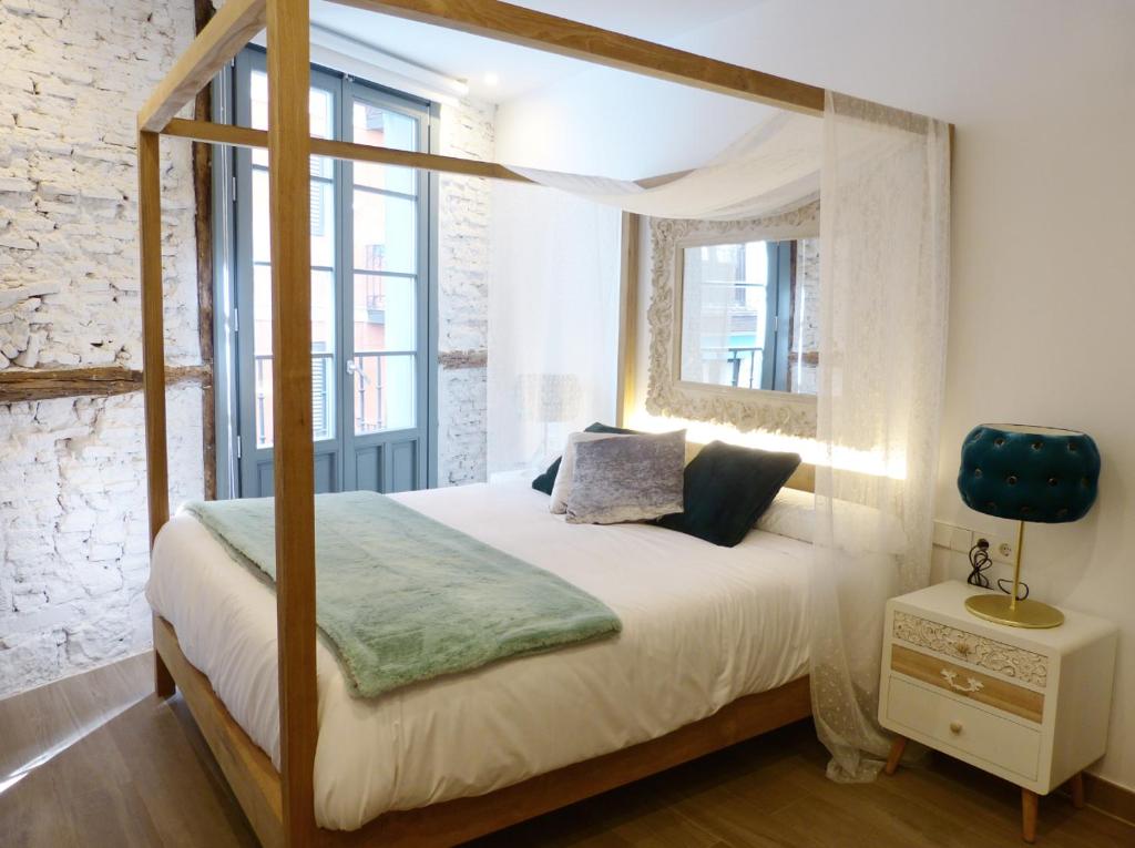 毕尔巴鄂Pensión Lo Bilbao的一间卧室设有天蓬床和窗户。