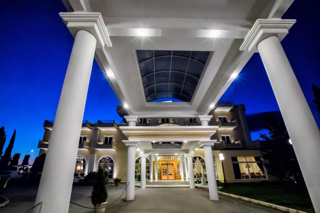 兹拉马克鲁罗斯酒店的一座白色的大建筑,晚上有柱子