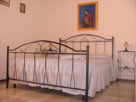 穆罗莱切塞Il Melograno的一间卧室配有带白色床单的金属床