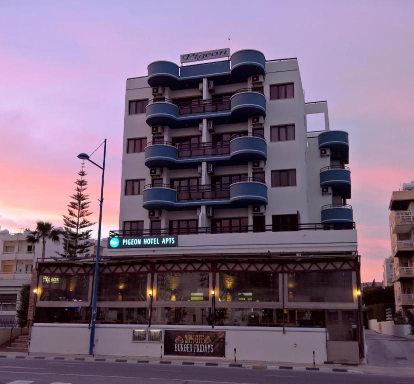 利马索尔雄鸽海滩公寓酒店的带有新主路标志的酒店大楼