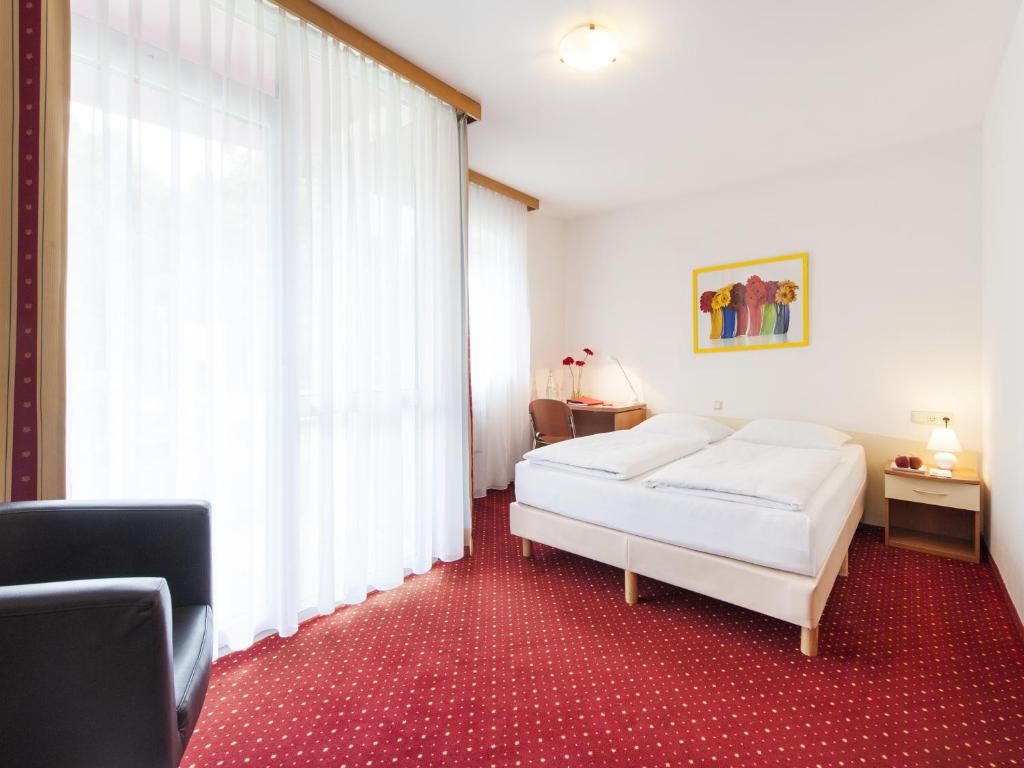 埃尔丁Andante Hotel Erding的一间卧室设有一张床和一个大窗户
