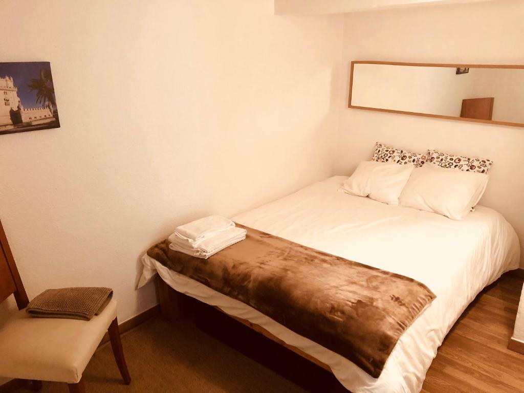 里斯本Lisbon Secret & Graca Apartment的小房间设有一张床和一把椅子
