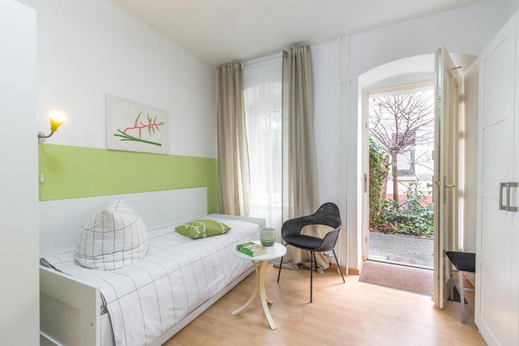 柏林Schönes 2-Zimmer-Apartment in Kollwitzplatz-Nähe的一间卧室配有一张床、一张桌子和一个窗户。