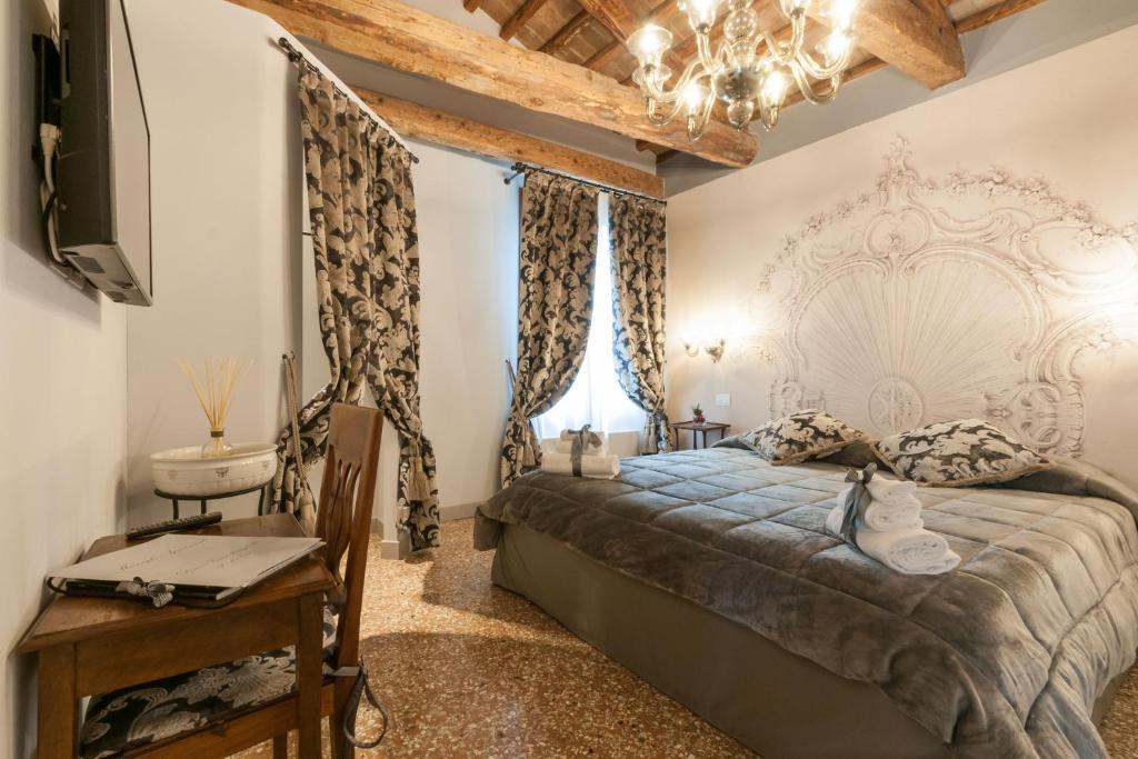 威尼斯San Marco Luxury apartments Muneghe的一间卧室配有一张床、一台电视和吊灯。