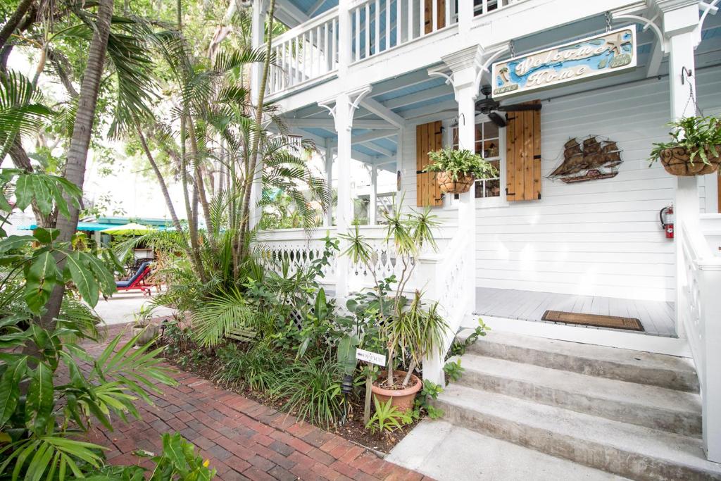 基韦斯特Key West Harbor Inn - Adults Only的棕榈树和楼梯的白色房子