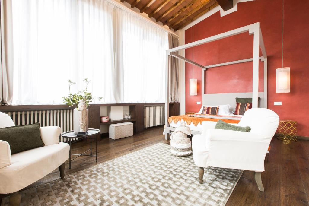 佛罗伦萨坎托德利斯卡利公寓酒店的一间卧室配有一张床和两把白色椅子