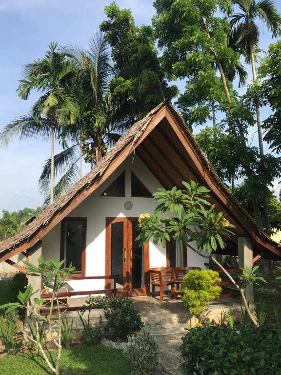 武吉拉旺Villa Paradise的茅草屋顶的小房子