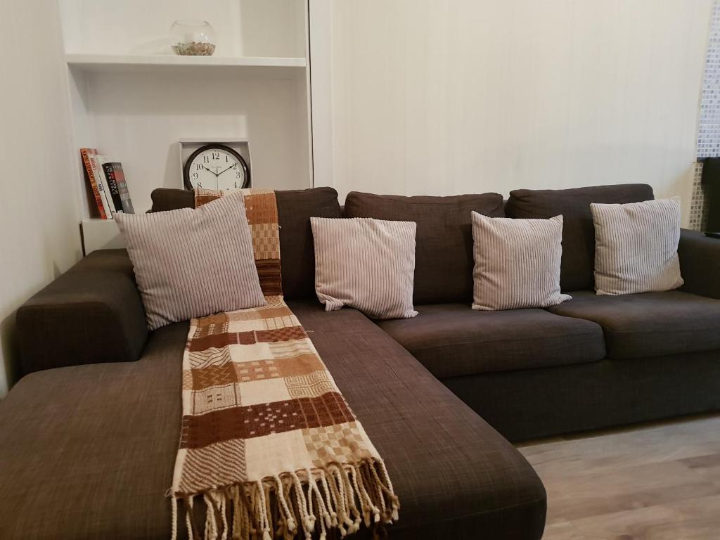 佩斯利Rozina Apartment的客厅配有带枕头的棕色沙发