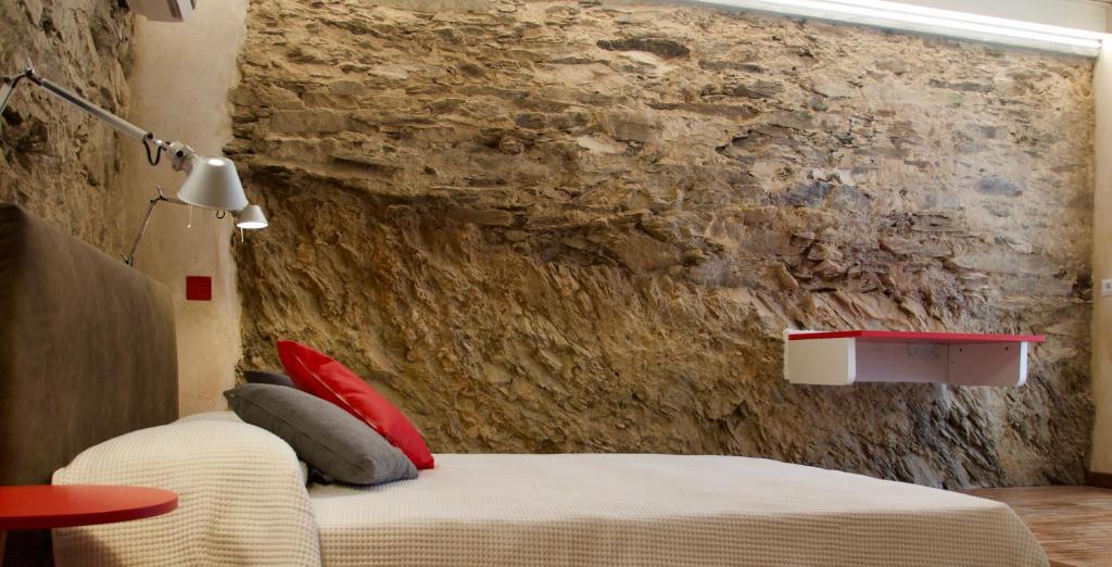 斯廷蒂诺B&B Mare di Fuori的一间卧室设有一张床和石墙