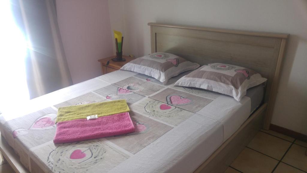 圣克罗蒂德Le Cap Vert的一张床上有粉红色钱包
