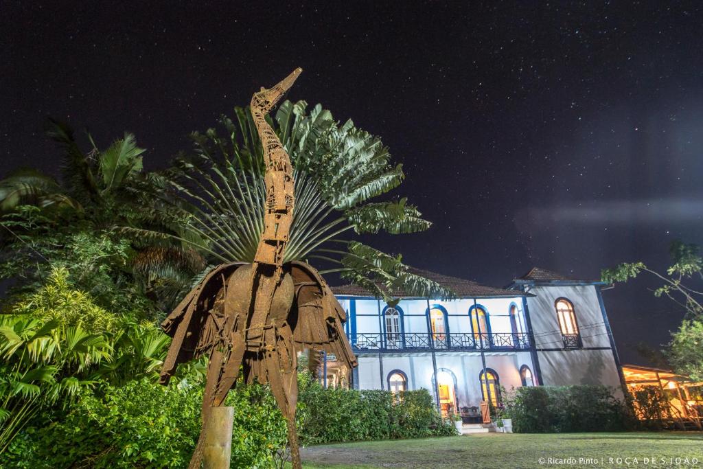 Santa CruzRoça São João dos Angolares的一座建筑前的棕榈树雕像