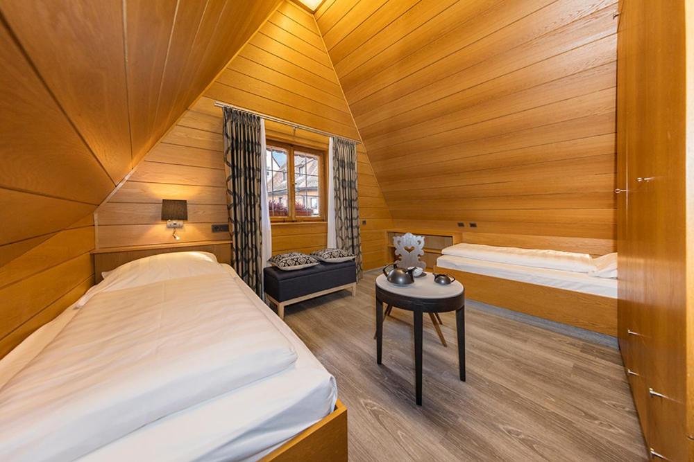 罗滕堡伯格酒店的一间卧室配有两张床和一张桌子。