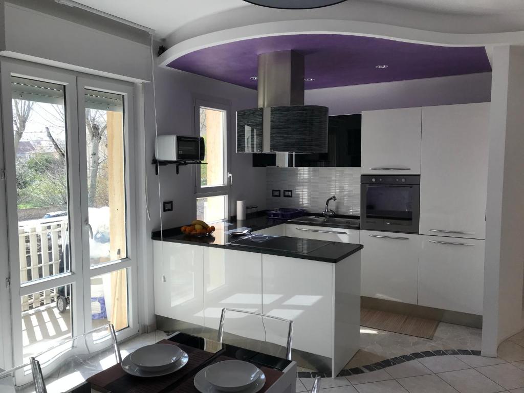 阿尔盖罗Dolce Sogno的厨房配有白色橱柜和紫色天花板