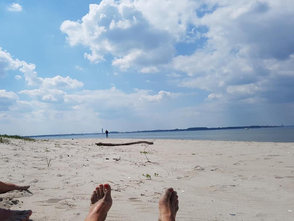 格罗斯施旺湖Seesternchen的坐在沙滩上的人,脚踏在沙滩上