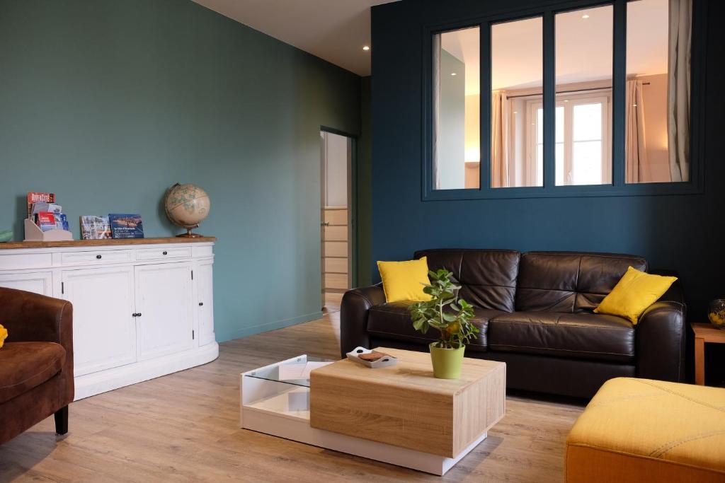 圣马洛Appartement Saint Malo-Rocabey的客厅配有棕色沙发和黄色枕头