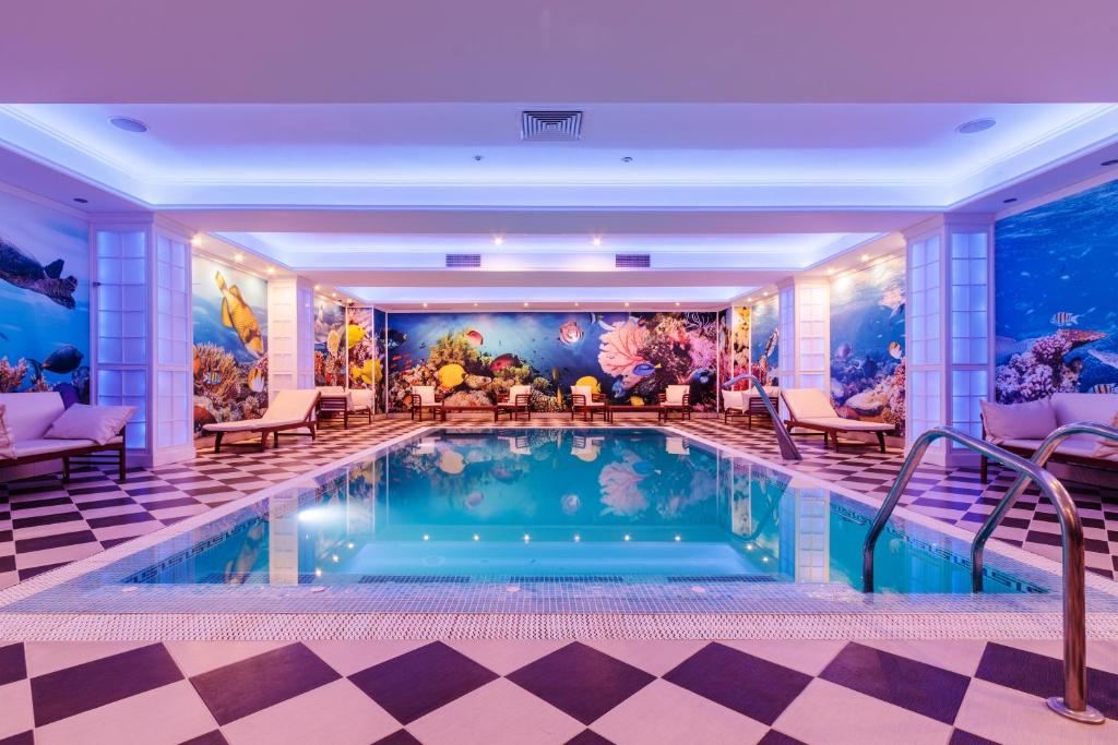 拉姆尼库沃尔恰索菲亚努大酒店的一个带壁画的酒店客房内的游泳池