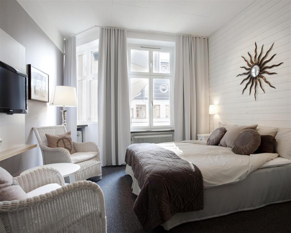 厄勒布鲁Hotel Örebro的一间卧室配有一张大床和两把椅子