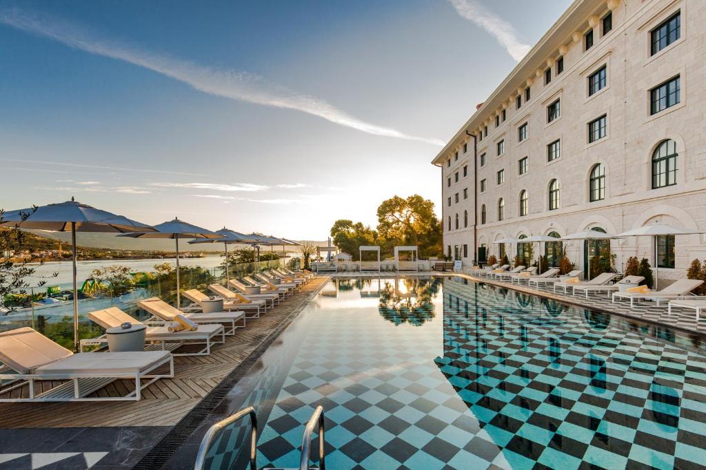 特罗吉尔布朗海滩豪斯酒店及Spa的酒店游泳池旁设有椅子和遮阳伞