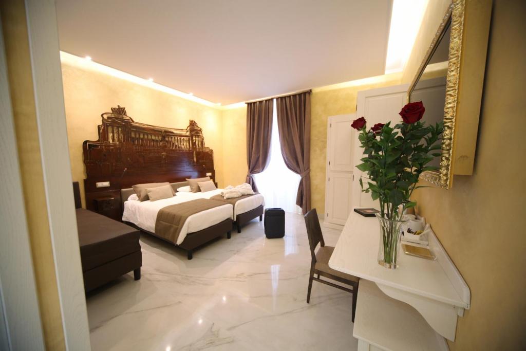 罗马三色旅馆的配有床和鲜花桌的酒店客房