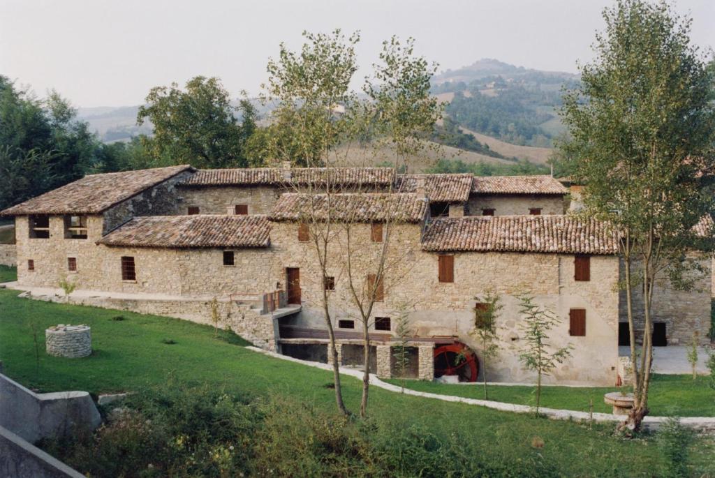 Nibbiano穆利诺伦提诺度假屋的一座古老的石头建筑,前面有树木