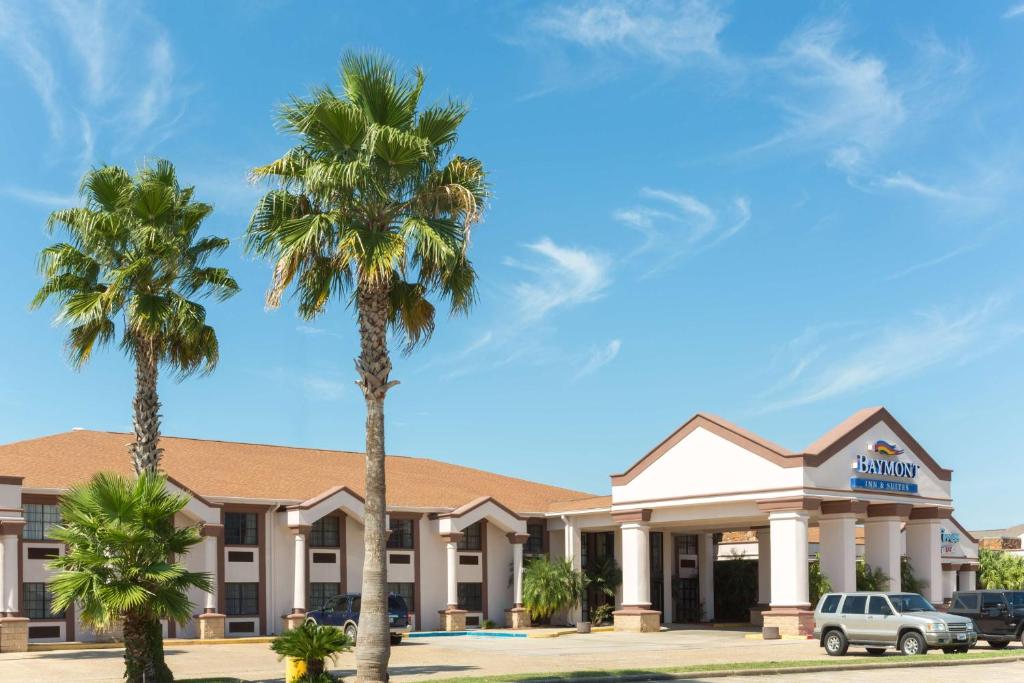 亚瑟港Baymont by Wyndham Port Arthur - Groves Area的前面有棕榈树的酒店