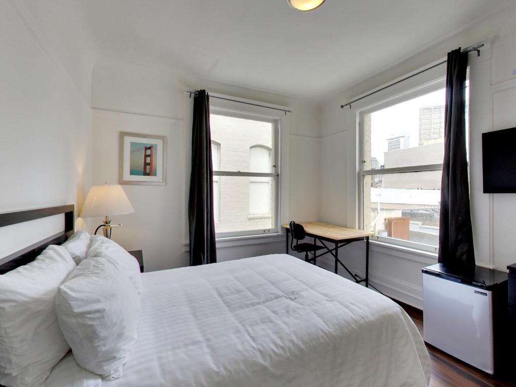 旧金山Hotel Ikon的卧室配有白色的床、书桌和窗户。