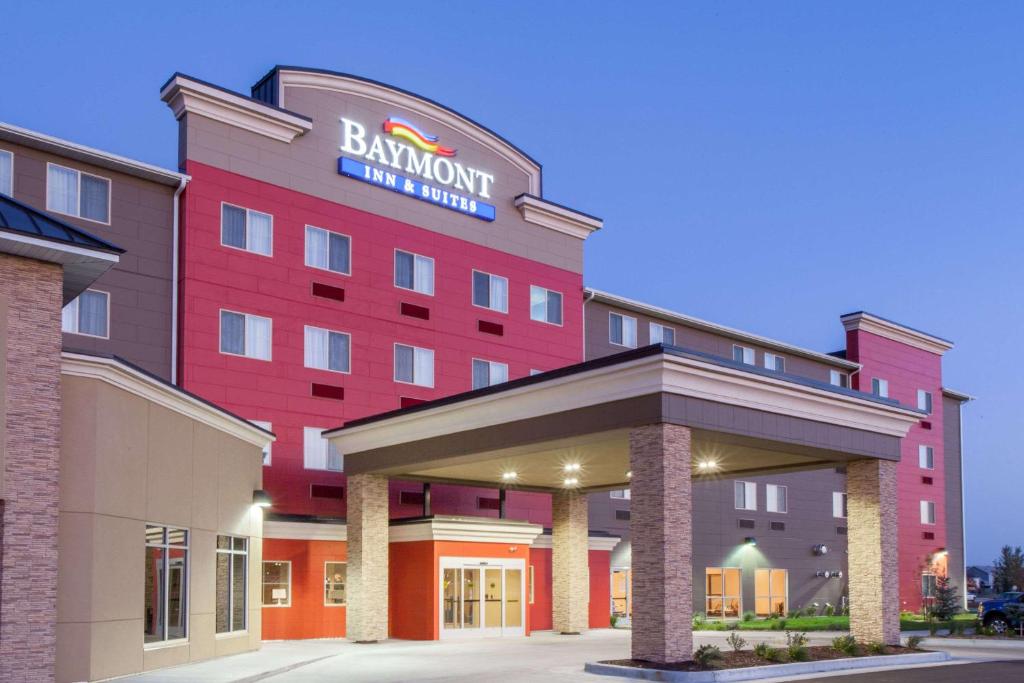 格兰福克Baymont by Wyndham Grand Forks的一间有红色建筑标牌的酒店