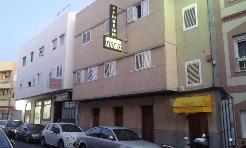 埃尔泰勒罗Pension Alvarez的门前有车辆停放的酒店