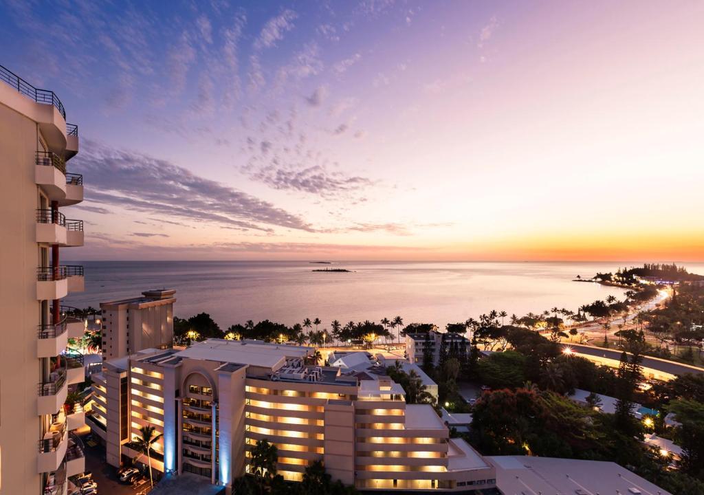 努美阿Ramada Hotel & Suites by Wyndham Noumea的享有海滩和夜间建筑的景色