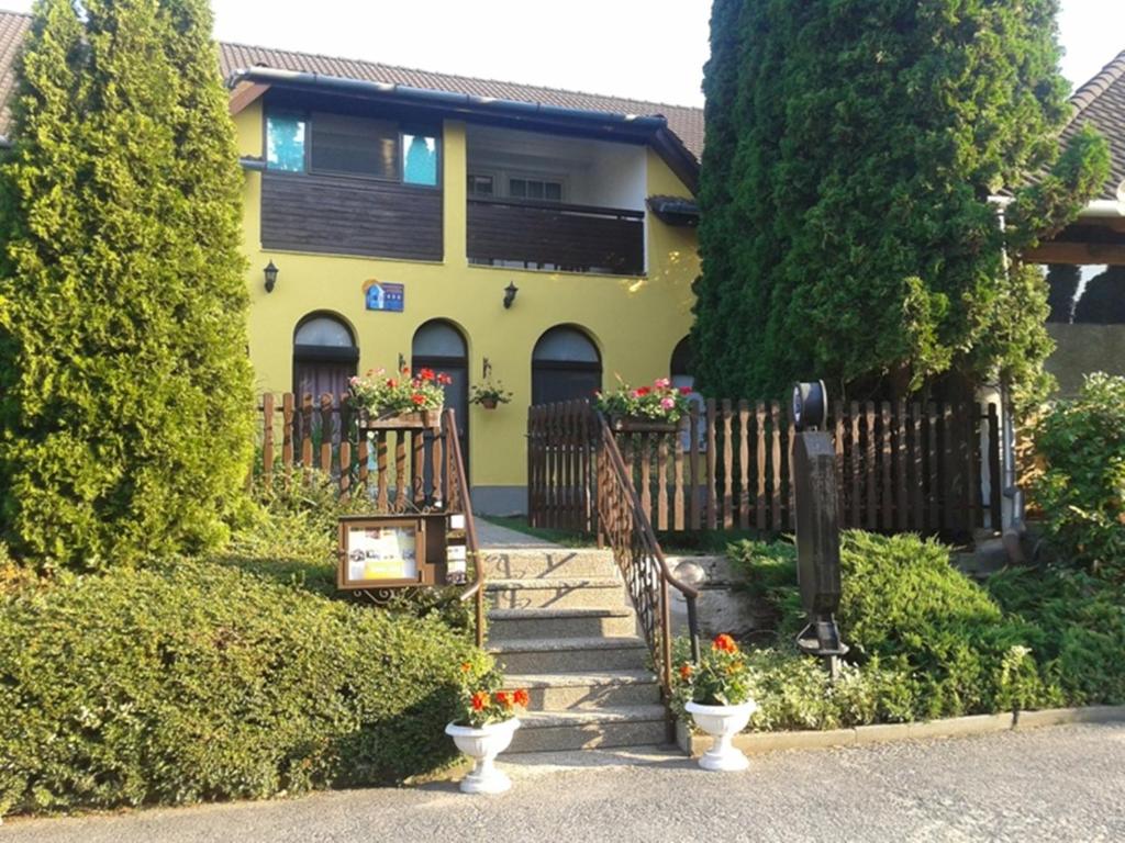 比克费赫尔罗佛格多酒店的黄色的房子,前面有楼梯和鲜花