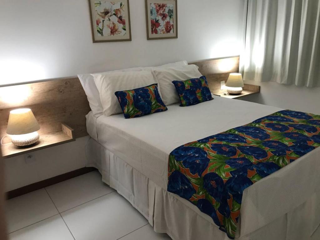 拉巴拉德纳圣米格尔Residence Iloa Resort的一张位于房间的床,桌子上放着两盏灯
