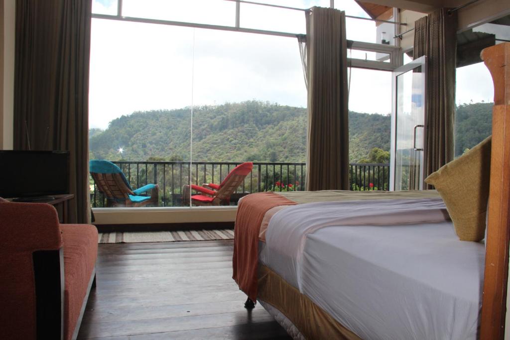 努沃勒埃利耶皮金斯奈斯特酒店的一间卧室设有一张床和一个美景阳台