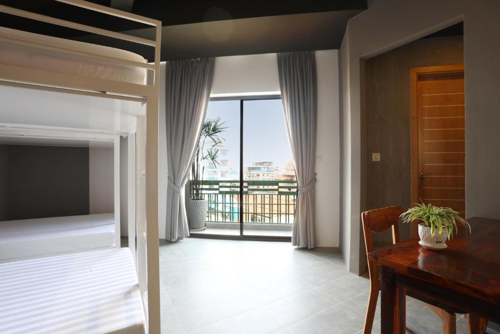 金边RS III地点旅馆的一间卧室配有一张床、一张桌子和一个窗户。