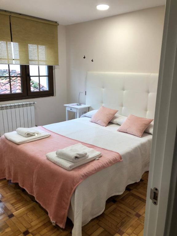 奥维多Madala XXI的卧室配有带粉红色枕头的大型白色床